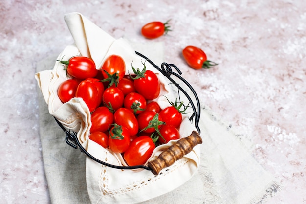 Pomodori ciliegia di vari colori, pomodori ciliegia gialli e rossi su sfondo chiaro