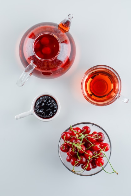 Cherry with tea, jam in a bowl, top view.