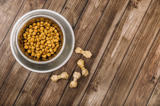 Chewing bones near bowl on floor