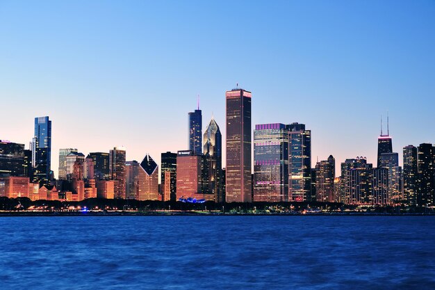 Городской горизонт города Чикаго в сумерках с небоскребами над озером Мичиган с ясным голубым небом.