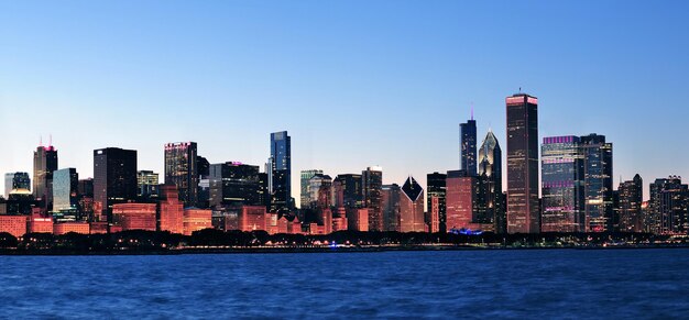 澄んだ青い空とミシガン湖の高層ビルと夕暮れ時のシカゴ市のダウンタウンの都市のスカイラインのパノラマ。