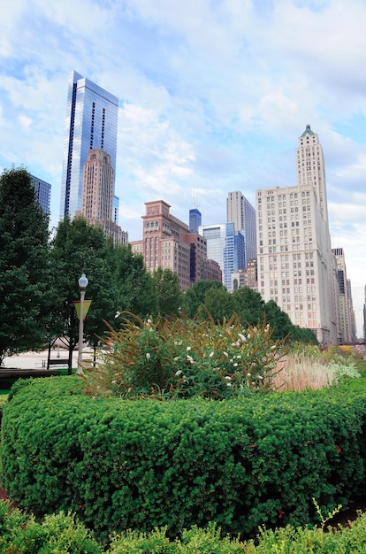 高層ビルと公園の上の曇りの青い空とシカゴ市のダウンタウンの都会のスカイライン。