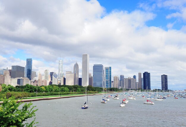 Chicago city downtown urban skyline with skyscrapers over Lake Michigan with cloudy blue sky.