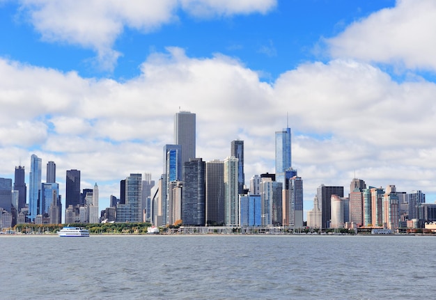 Chicago city urban skyline with skyscrapers over Lake Michigan with cloudy blue sky.