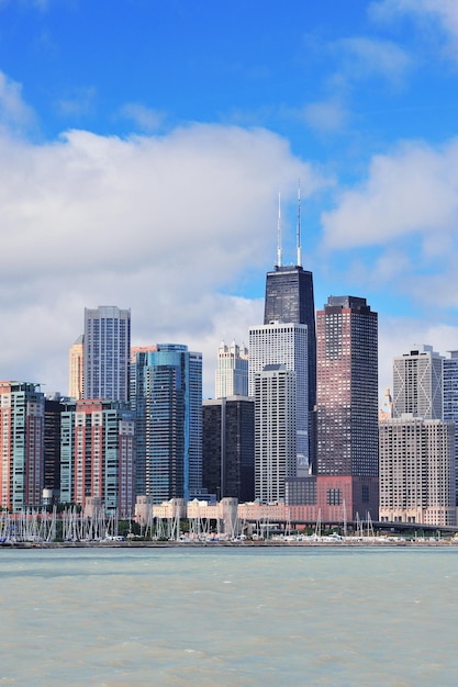 Chicago city urban skyline with skyscrapers over Lake Michigan with cloudy blue sky.