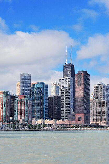 Chicago city urban skyline with skyscrapers over Lake Michigan with cloudy blue sky.
