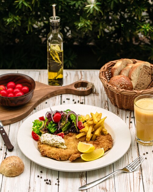 Chicken breast served with fries and vegetables