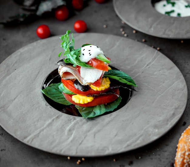 Free photo chicken breast slices served with tomato cucumber basil and arugula