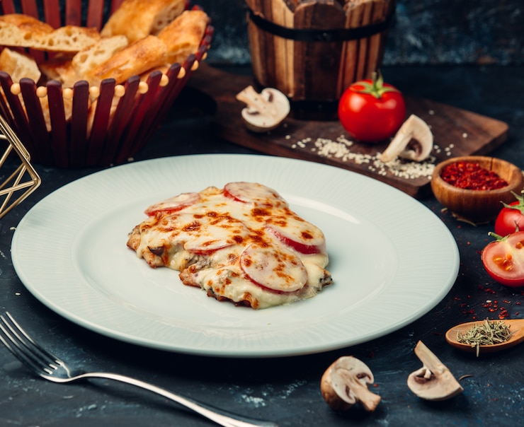 Бесплатный Фотография куриная грудка с плавленым сыром и ломтиками помидоров.