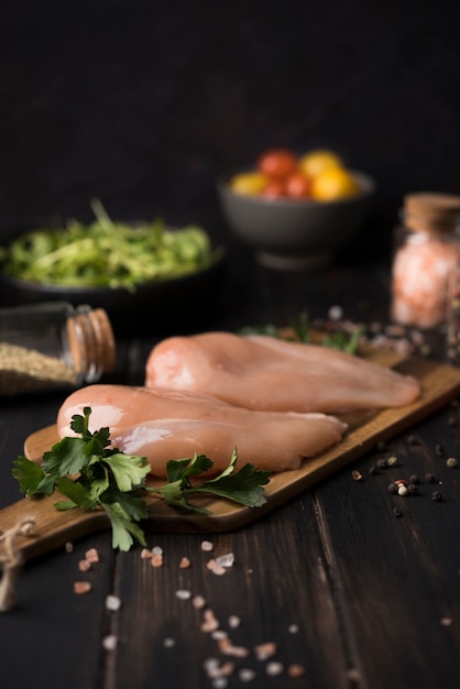 Chicken breast on wooden board with ingredients