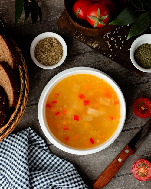 Chicken broth vegetable soup in a white bowl