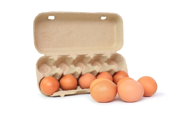 鶏の茶色の卵と白い背景の上の卵のカートンボックス。