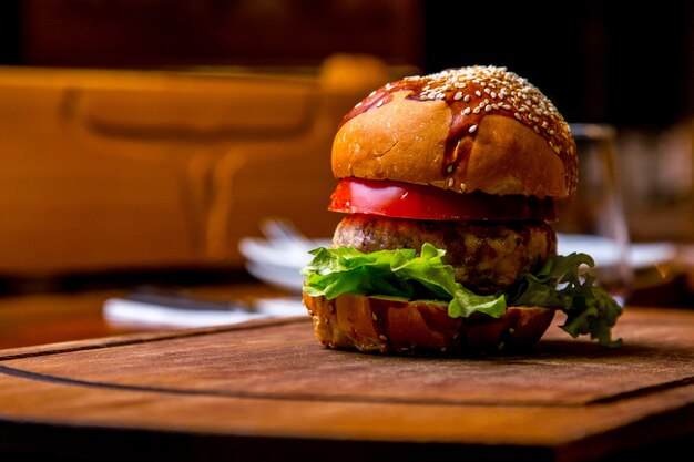 Chicken burger on wooden board side view