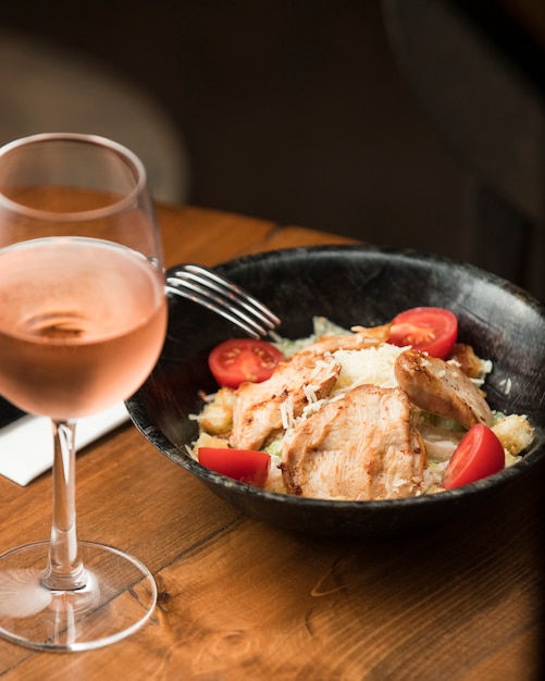 Foto gratuita insalata di pollo caesar con vino rosato