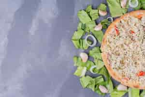 Free photo chicken cheesy pizza on blue with fresh vegetables.