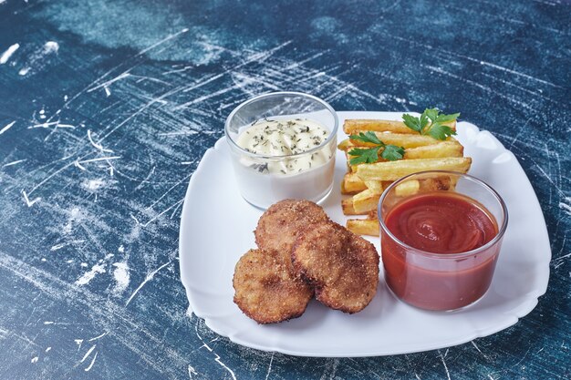 Chicken cotlets with french fries and ketchup.