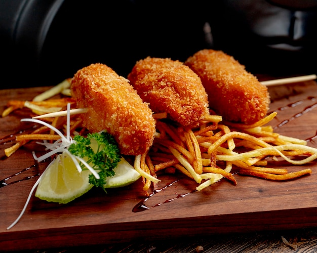 Foto gratuita cotolette di pollo servite con patatine fritte