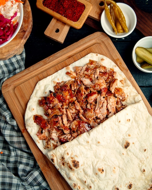 Chicken doner kebab in flatbread served with pickled cucumber and pepper