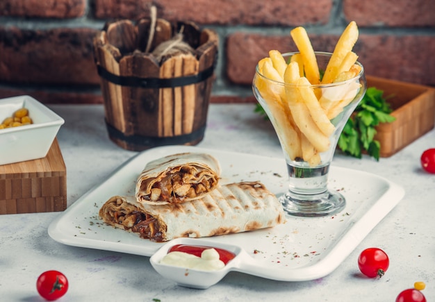 chicken doner in lavash with french fries in the plate