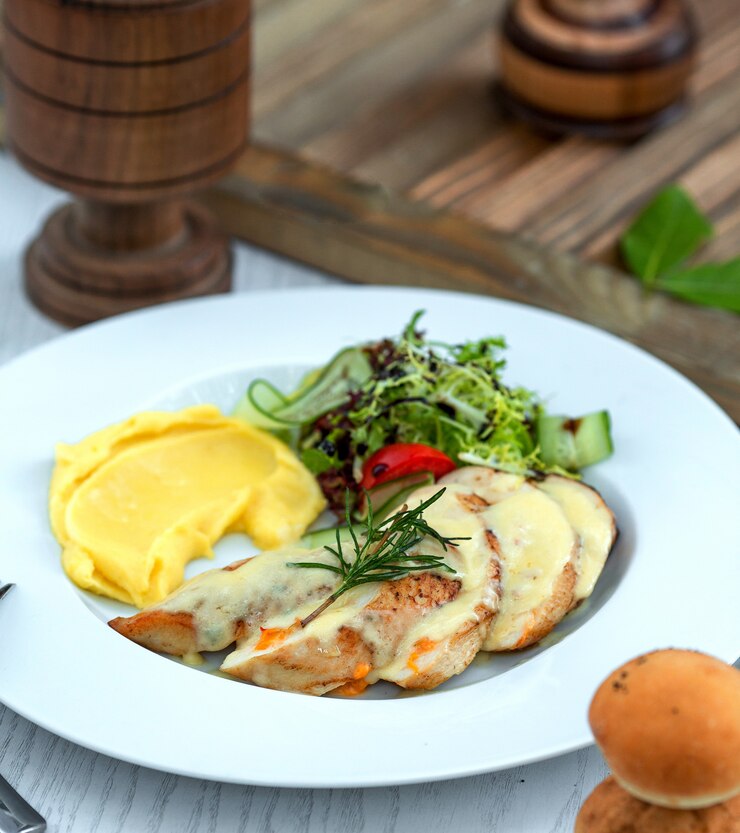 Free Photo chicken drenched in sauce with side mashed potatoes