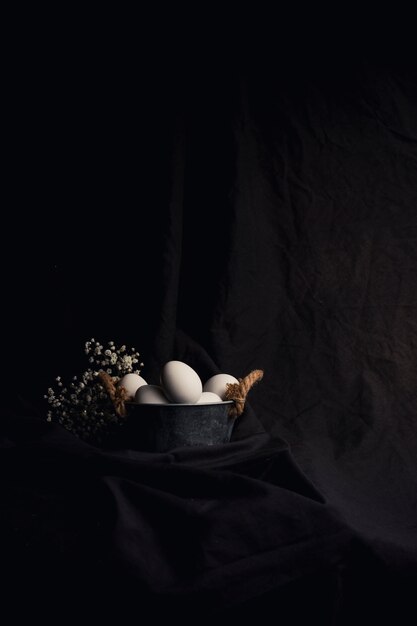 Куриные яйца в миске возле растения