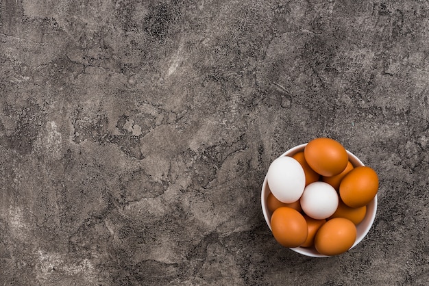 Chicken eggs in bowl on table