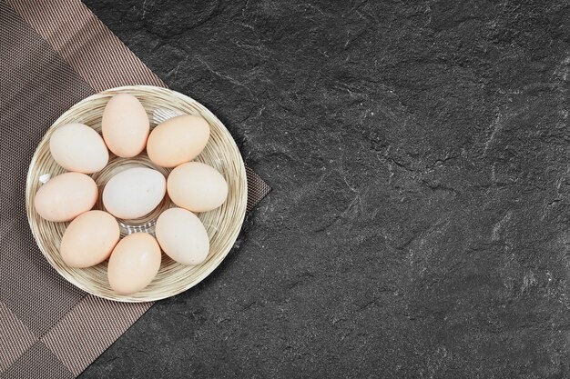 Куриные яйца на керамической тарелке. Вид сверху.