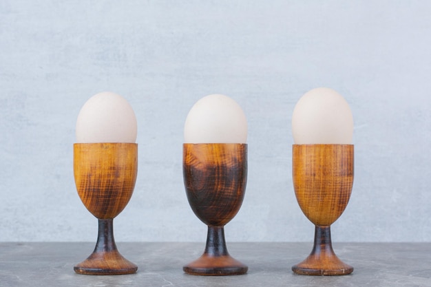 무료 사진 대리석 배경에 계란 컵에 닭고기 달걀입니다. 고품질 사진