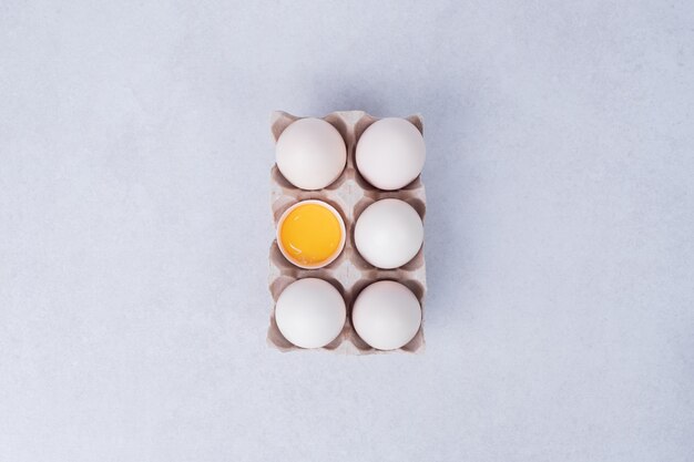 흰색 표면에 종이 용기에 닭고기 달걀.