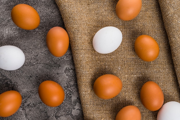 Chicken eggs scattered on canvas on table