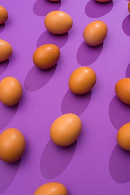 Free photo chicken eggs scattered on purple table