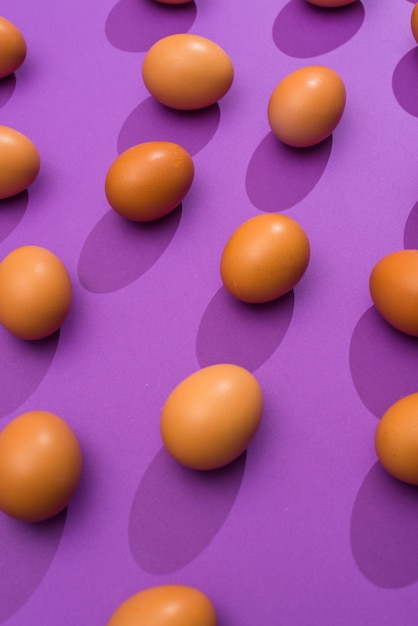 紫色のテーブルに散在している鶏の卵