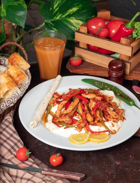 Chicken fajita, chicken fillet fried with bell pepper in lavash with bread slices in white plate 