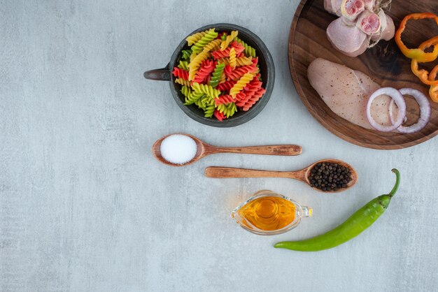 Куриное филе и овощи на деревянной тарелке с макаронами.