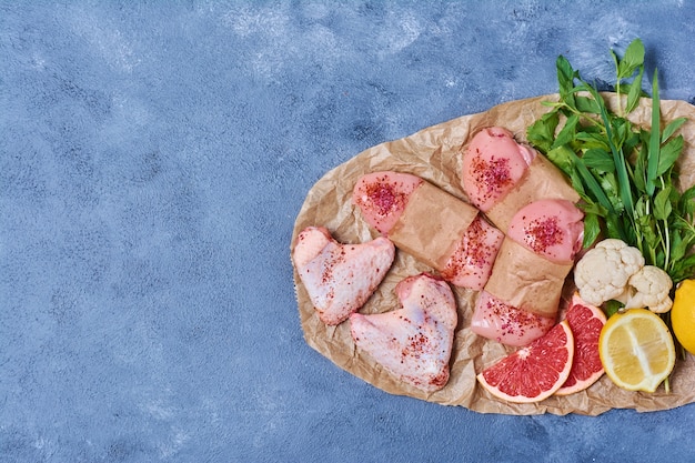 Chicken fillet with spices on a wooden board on blue