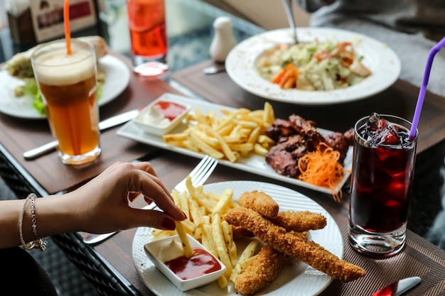 Free photo chicken fingers with french fries juice sauce lemonade