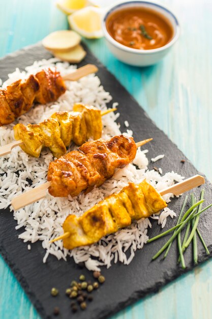 Chicken kebab and rice near condiments