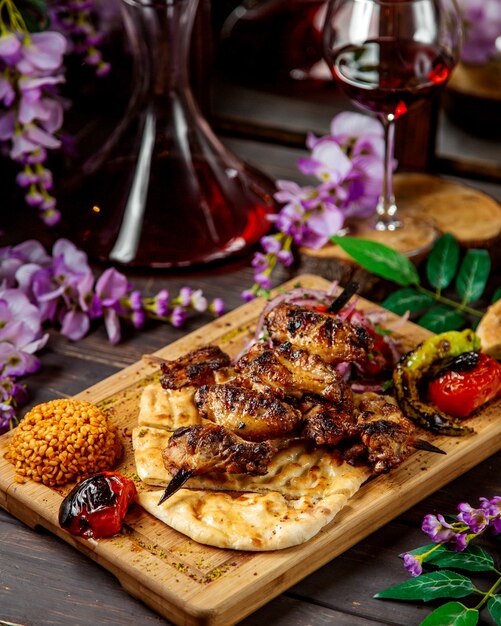 Chicken kebab on skewers served with bulgur grilled vegetables and bread
