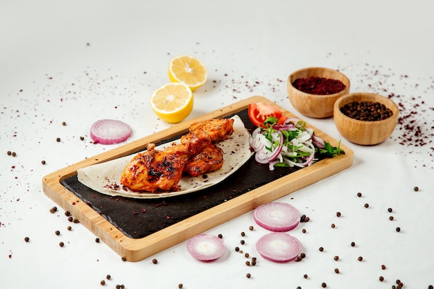 Chicken kebab with onions on a wooden board