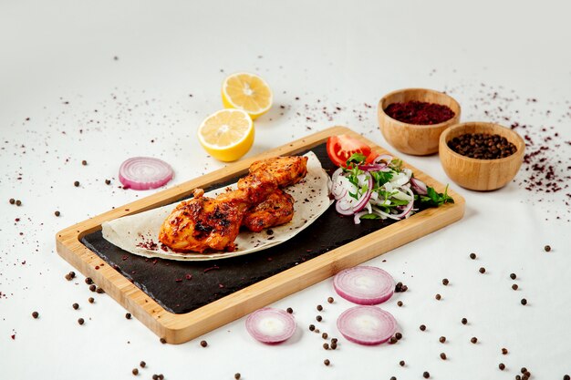 Chicken kebab with onions on a wooden board