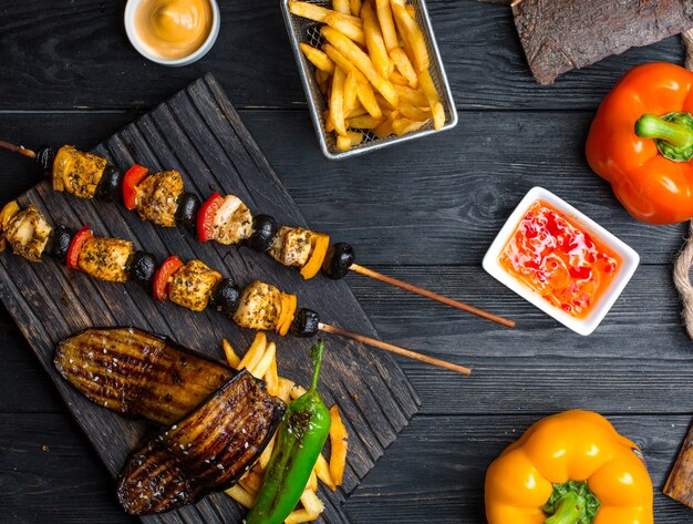 Chicken kebab with vegetables with french fries on the table