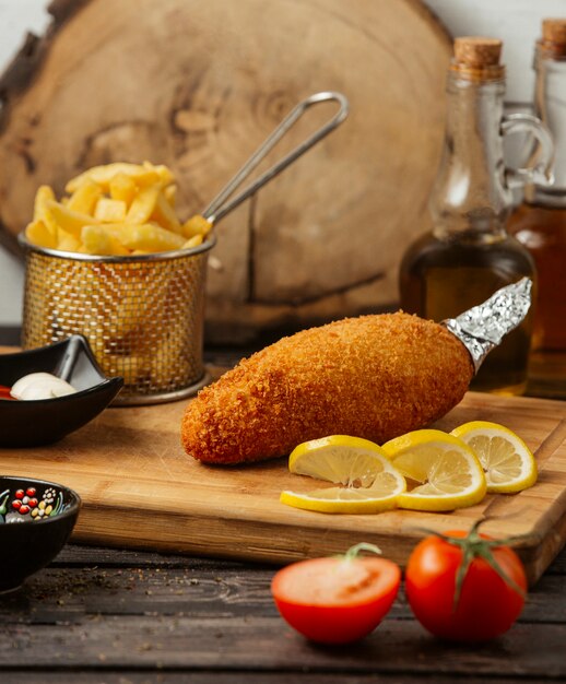 chicken kiev served with fries, lemon, mayonnaise and ketchup