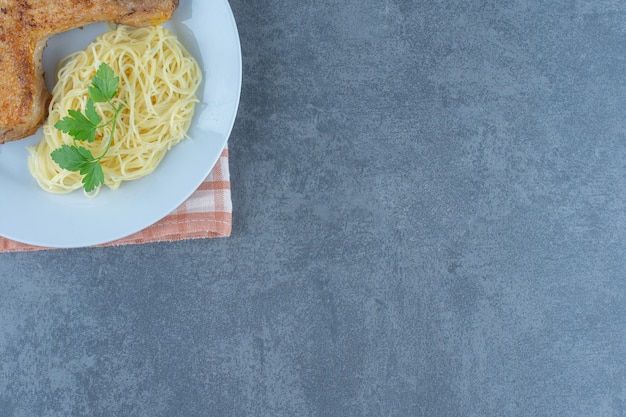Delicious Chicken Leg and Spaghetti on a White Plate
