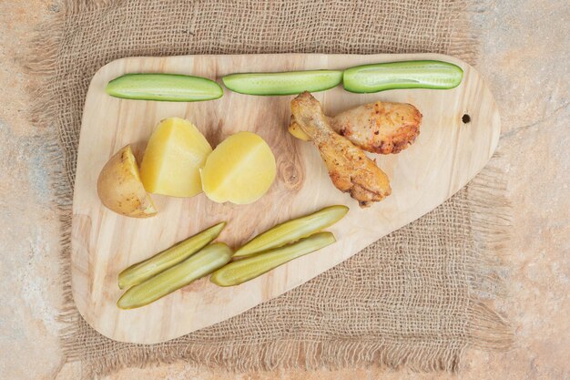 Coscia di pollo con varie verdure su tavola di legno