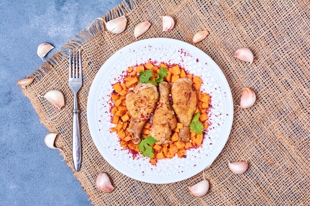 Foto gratuita cosce di pollo con salse in un piatto bianco.