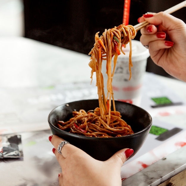 Chicken noodles in a black bowl