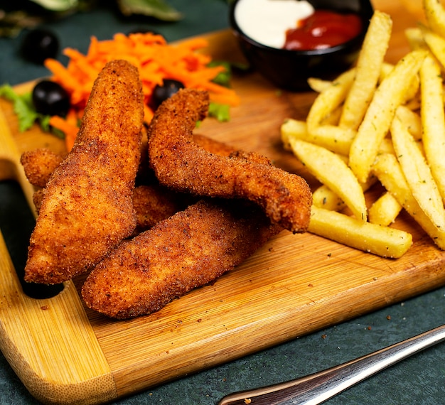 Crocchette di pollo in stile kfc con patatine fritte, maionese, ketchup e insalata di verdure