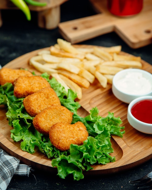 フライドポテト、ケチャップ、マヨネーズを添えたチキンナゲット