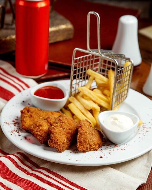 Chicken nuggets served with french fries mayonnaise and ketchup