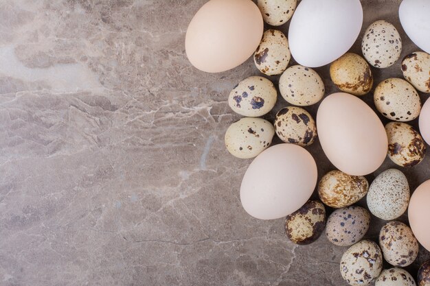 Chicken and quail eggs on marble.